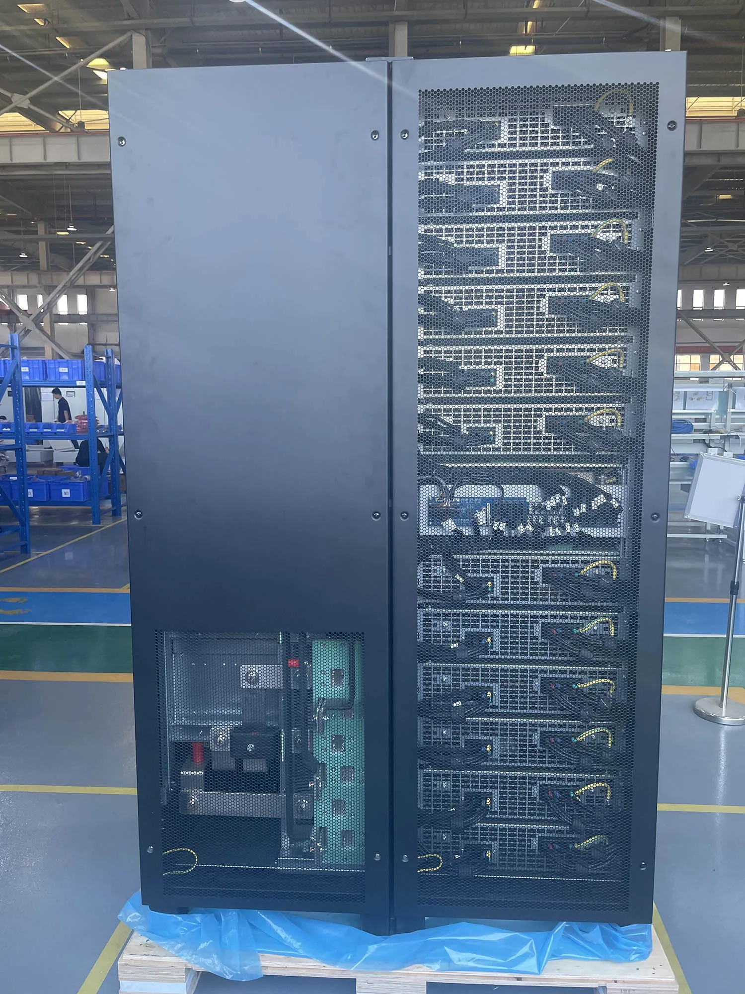 Three-phase online UPS cabinet with front doors open, power modules visible